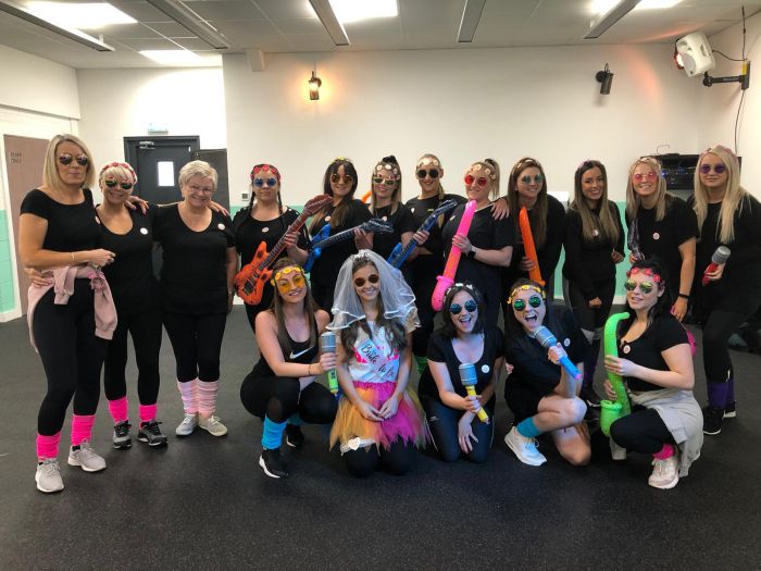 Hen party group with pom-poms cheerleading Brighton